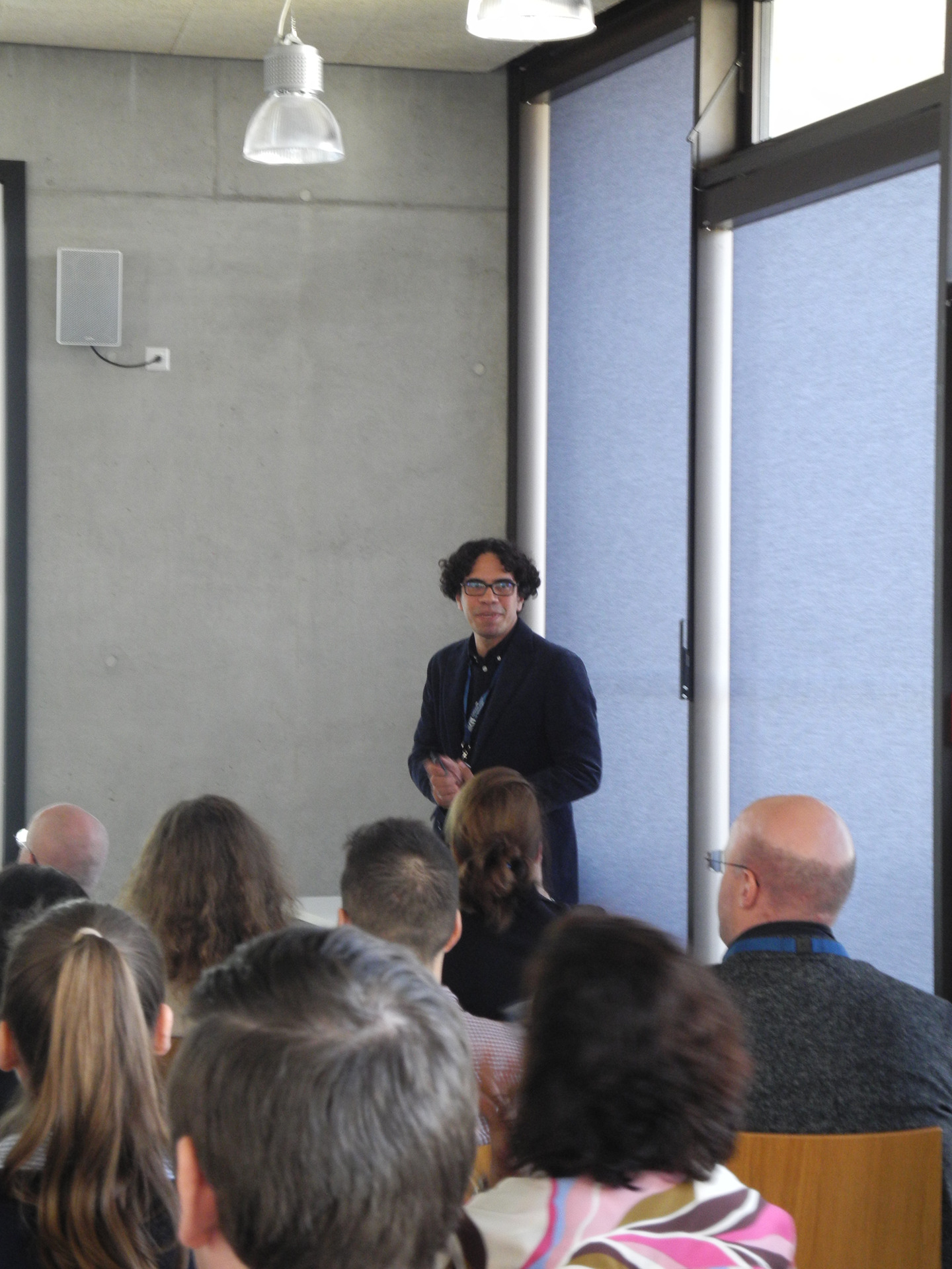 M&auml;nnlicher Redner steht vor einer Gruppe von Zuh&ouml;rern in einem Auditorium.